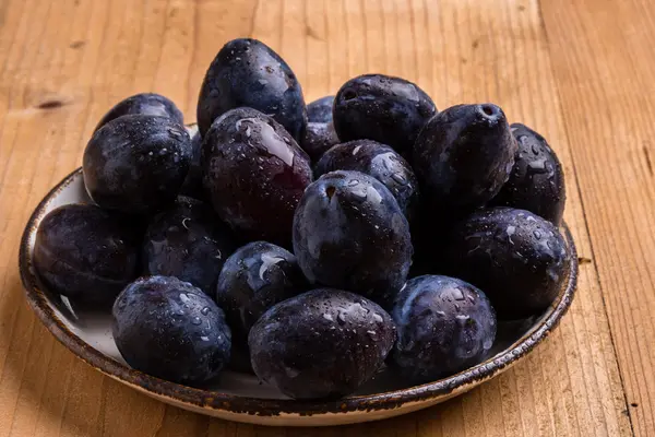 Fresh plums on wooden table — Stock Photo, Image