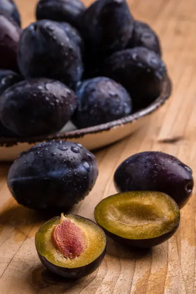 Fresh plums on wooden table — Stock Photo, Image