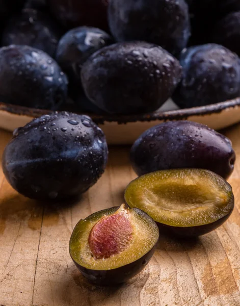 Fresh plums on wooden table — Stock Photo, Image