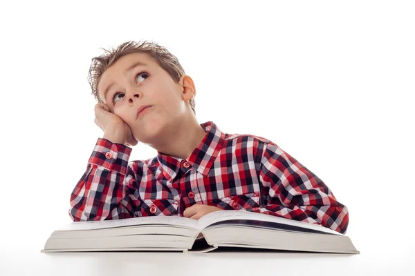 Фантазирующий мальчик с книгой — стоковое фото