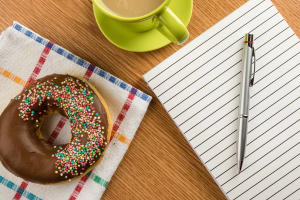 Donut-Kaffee und Notizblock mit Stift — Stockfoto