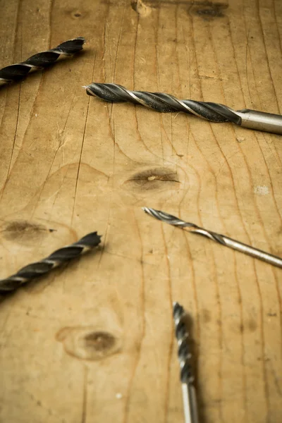 Drill bits on wooden table — Stock Photo, Image