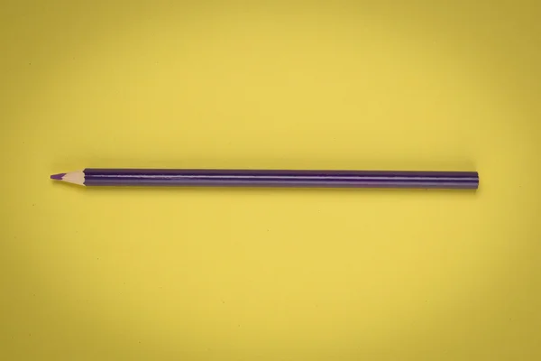 Lápiz violeta sobre papel amarillo — Foto de Stock