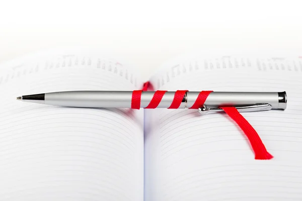 Pluma en cuaderno con cuerda roja — Foto de Stock