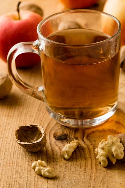 Té con manzanas y nueces en la mesa de madera —  Fotos de Stock