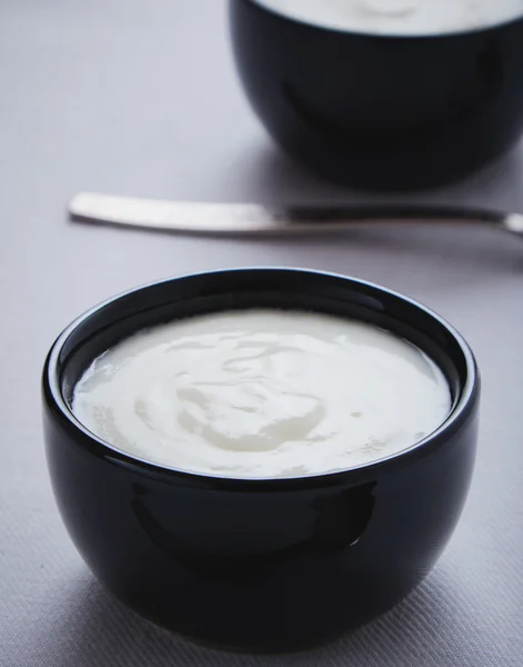 Yogurt en tazón negro — Foto de Stock