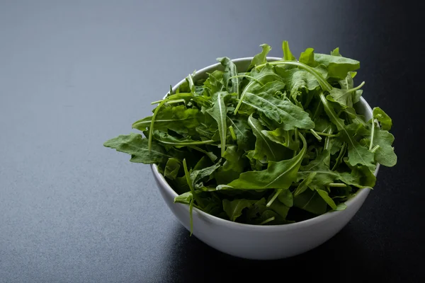 Rucola dans un bol blanc — Photo