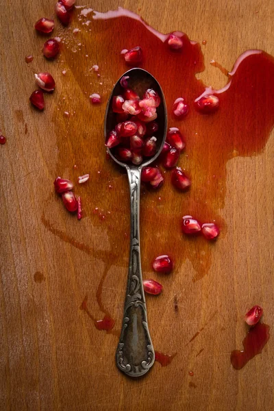 Pomegranate seeds in a spoon — Stock Photo, Image