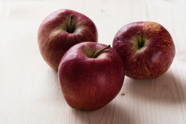 Red apples on wooden table — Stock Photo, Image
