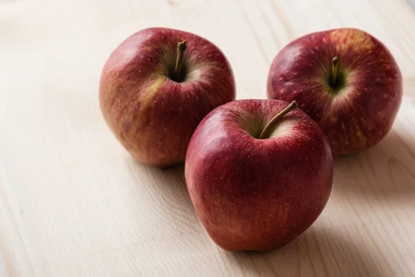 Red apples on wooden table — Stock Photo, Image