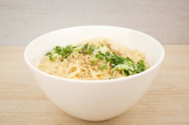 Beyaz çorbada hazır şehriye. Et suyu çorbası. Lezzetli erişte. Yeşil soğanlı tabak.