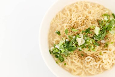 Beyaz çorbada hazır şehriye. Et suyu çorbası. Lezzetli erişte. Yeşil soğanlı tabak.