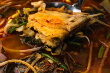 Kemikli ve başlı haşlanmış balık. Balık ve sebze çorbası pişiriyorum. Baharatlı ve sıcak Kore yemekleri.