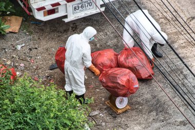Bangkok, Tayland 03.26.2021 Atık Yönetimi çalışanları Cotai Lüks Tasarım Alternatif Devlet Karantina Oteli atıklarını kişisel koruma ekipmanlarıyla topluyorlar.