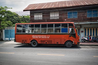 Bangkok, Tayland 04.28.2021 Bangkok 'un sakin bir sokağında eski turuncu otobüs parkı.