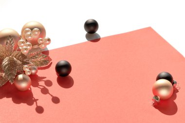 Yılbaşı aranjmanı beyaza izole edilmiş ve metin alanı var. Siyah Xmas bibloları ve böğürtlenli altın dal. Pembe kağıt üzerinde Xmas dec. Gölgeli doğrudan güneş ışığı.