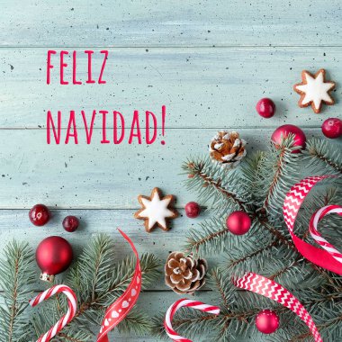 Text Feliz Navidad means Merry Christmas in Spanish. Low impact living, natural Christmas decorations with fir twigs. Ribbons, star cookies, baubles,cranberry berry and pine cones. clipart