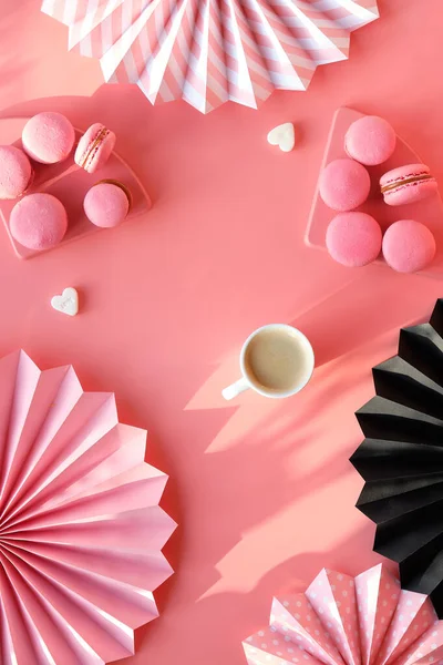 ピンク色の紙に創造的なモノクロフラットレイ ハッピーバレンタインおいしいマカロンとコーヒー 紙のファンや砂糖の心を折り畳んだ 太陽の光や長い影 — ストック写真