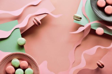 Uçan kurabiyelerle havalanma ve denge kompozisyonu. Doğal güneş ışığı. Somon pembesi ve nane yeşili renklerde katmanlı kağıt arka plan. Soyut şekiller, çizgiler. Matisse esinlenilmiş kolaj, kağıt sanatı.