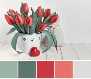 Bahar kutlamasının görüntülerindeki renge uyan palet. Basit doğal sıfır atık tebrik kartı tasarımı. Bir sürü lale ve kırmızı taş kalp. Beyaz ahşap bir masa..