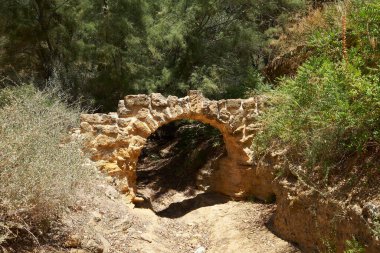 Kolymbethra Bahçeleri ya da Jardino della Kolymbethra. İtalya, Sicilya 'daki Tapınaklar Vadisi' nin kalbindeki muhteşem yeşil bahçe. Yaya yolu ve bahçe duvarının üzerinde taş kemer.