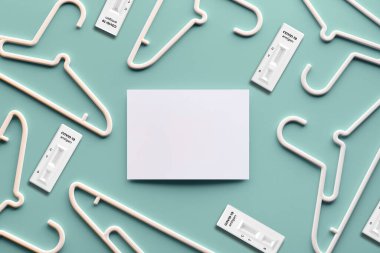 Beyaz plastik askılar, beyaz kağıt üzerinde fotokopi alanı. Yaratıcı üst görünüm modayı takip eden pastel yeşil neo-nane arkaplanı, yaratıcı minimalizm üzerine kuruludur. Düz yatak, satış konsepti, online alışveriş, harika fiyatlar..