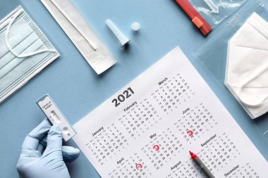 Ekspres COVID-19 test programı. Schnelltest hızlı korona testi demektir, Selbsttest de kendini test etmek demektir. Eldivenli düz yerde yatarken antijen testi yapın. İşaretli tarihli 2021 takvimi, pp2 maskesi.