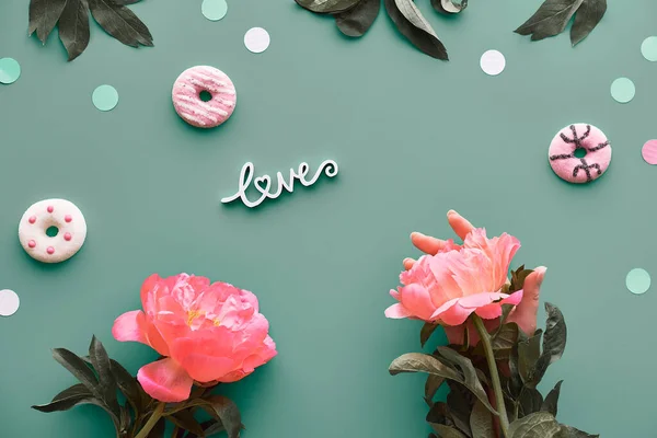 牡丹のグリーティングカード 灰色の背景の言葉の愛 ピンクの牡丹の花 葉と甘いドーナツ ドーナツ 母の日 誕生日 ロマンチックなグリーティングカードフラットレイデザイン — ストック写真