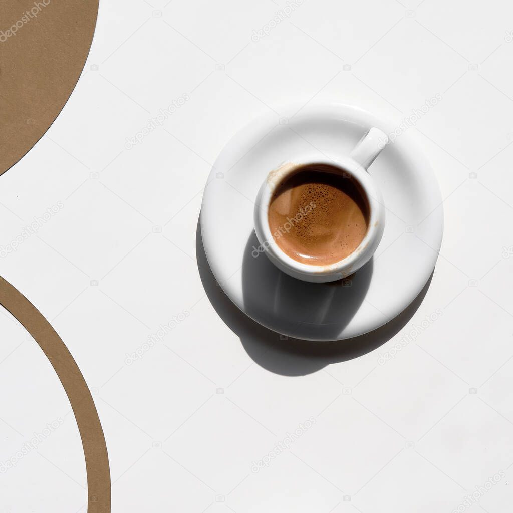 Espresso coffee cup, simple minimal arrangement. White brown geometric flat lay, top view, square composition.