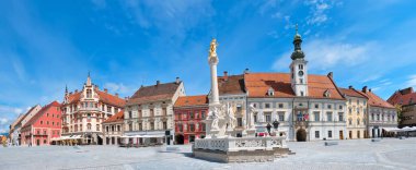 Banner, Slovenya 'daki Maribor şehir merkezi. Maribor Meydanı 'ndaki belediye binası ve veba anıtı. Mavi gökyüzü, parlak gün ışığı, panoramik şehir manzarası. Avrupa 'nın ünlü turizm beldesi.