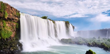 Arjantin 'de Iguazu şelaleleri, Şeytan Ağzı manzaralı. Sis ile çağlayan birçok görkemli ve güçlü suyun panoramik görüntüsü. Geniş ve güçlü şelalenin yan görüntüsü. Turkuaz su ve taşlar.