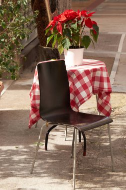 Restorandaki masa, açık hava kafesi kırmızı noktalı çiçek ve kırmızı beyaz kareli masa örtüsü. Restoranlar, koronavirüs salgınından sonra açık veranda açarlar. Atina, Yunanistan 'daki Restoran