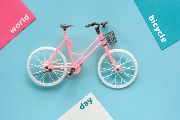 World Cycling Day, Bicycle Day on June 3. Toy model town bike with shadow on mint blue background. Flat lay, top view, minimal retro vintage geometric concept design.