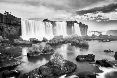 Iguazu waterfalls in Argentina, black white picture. View from Devil's Mouth. Majestic powerful water cascades with mist. Monochrome image. clipart