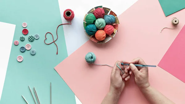 ウール糸 綿玉と編み針 かぎ針編みで手 創造的な趣味の工芸品 層状ピンク ミントグリーンの創造的な配置 パステルカラーのパノラマ紙の背景 — ストック写真