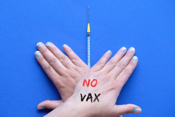 ワクチン拒否の概念 ワクチン注射器の上にテキストNo Vaxで交差手 麻疹の予防接種を拒否する人 Covid 青い紙に拒否ジェスチャーで予防接種の概念 — ストック写真