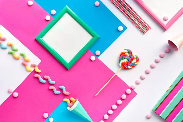几何平板纸上的聚会对象集合 生日装饰 巧克力 糖果和彩虹棒棒糖旋涡 白色桌子上用粉红色和薄荷蓝色表示的几何层次分明的背景 — 图库照片
