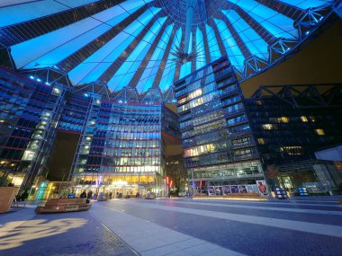Berlin, Almanya CIRCA Şubat 2026: Potsdamer Platz 'daki Sony Center alacakaranlıkta aydınlık cam tepe örtüsü ve çevresindeki ofis binaları, bankları, aydınlık dükkan önleri ve banliyöleri olan geniş yaya plazası..