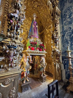Barcelos, Portekiz - 14 Şubat 2026: Templo do Temhor Bom Jesus da Cruz 'daki süslü sunak, mor mantolu Marian heykeli, oyulmuş melekler ve yaldızlı ahşap işçiliği ve azulejo fayanslarıyla çerçevelenmiş polikrom figürleri