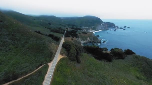米国カリフォルニア州カスラーポイント付近の海岸沿いの道路や霧に覆われた緑の丘のドローン映像 — ストック動画