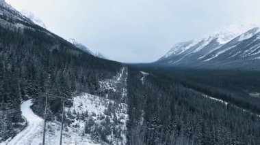 İnsansız hava aracı Kananaskis, Alberta, Kanada 'da karlı, fazla gelişmiş bir dağ yamacının üzerinden alçaktan uçuyor.