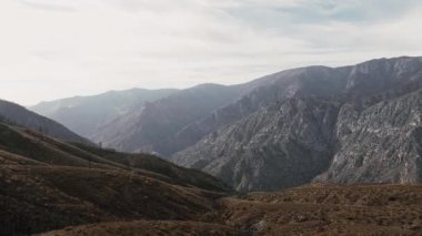 İHA kamerası gri dağların üzerinden sorunsuzca geçiyor ve ABD 'nin Kaliforniya eyaletindeki Sequoia Ulusal Parkı' nda ufuk çizgisini çekiyor.
