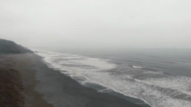 Islak bir sahildeki beyaz okyanus dalgalarının, Kaliforniya 'daki Dry Lagoon State Park' taki Sharp Point yakınlarındaki sise olan hava görüntüleri.