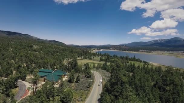 Drone schiet een huis met een groen dak in het bos op het meer, Big Bear Solar observatory, luchtfoto uitzicht op Big Bear Lake, Californië, Verenigde Staten — Stockvideo