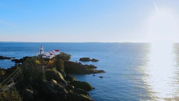 Une caméra aérienne appose le phare de Head Harbour par une soirée ensoleillée, prise de vue par drone depuis l'île Campobello, Nouveau-Brunswick, Canada — Video