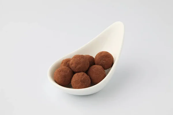 Trufas de chocolate na placa no fundo branco — Fotografia de Stock