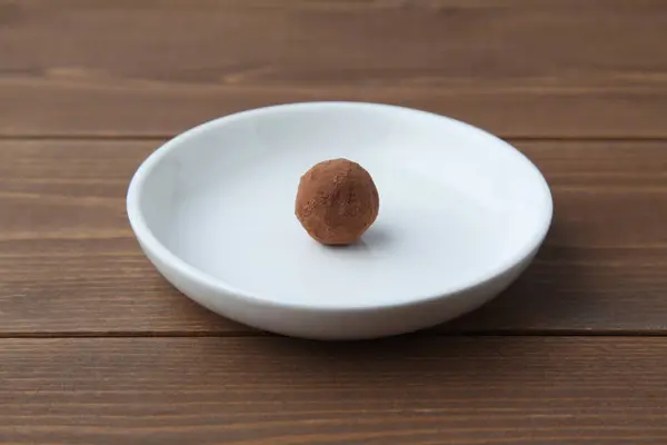 Trufa de chocolate na placa na mesa de madeira — Fotografia de Stock