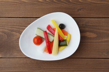 Turşu turşulu sebze salatası. Tahta masada izole edilmiş.