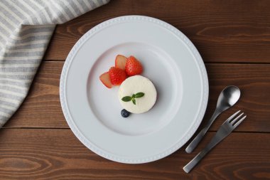 Tabaktaki beyaz şifon peynirli kek ahşap masada izole edilmiş.