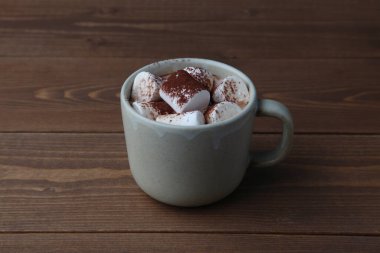 Tahta masaya izole edilmiş lokum kaplı sıcak çikolata.